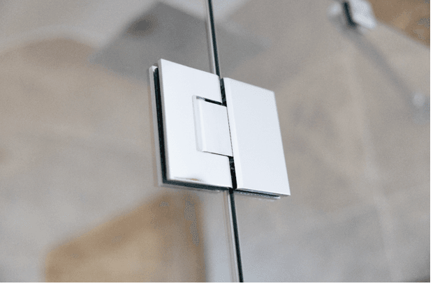 A close up of a glass shower door hinge 