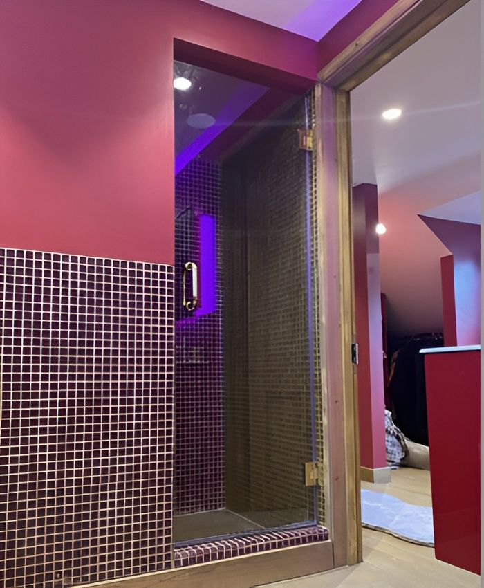 A single shower door enclosure in a pink bathroom