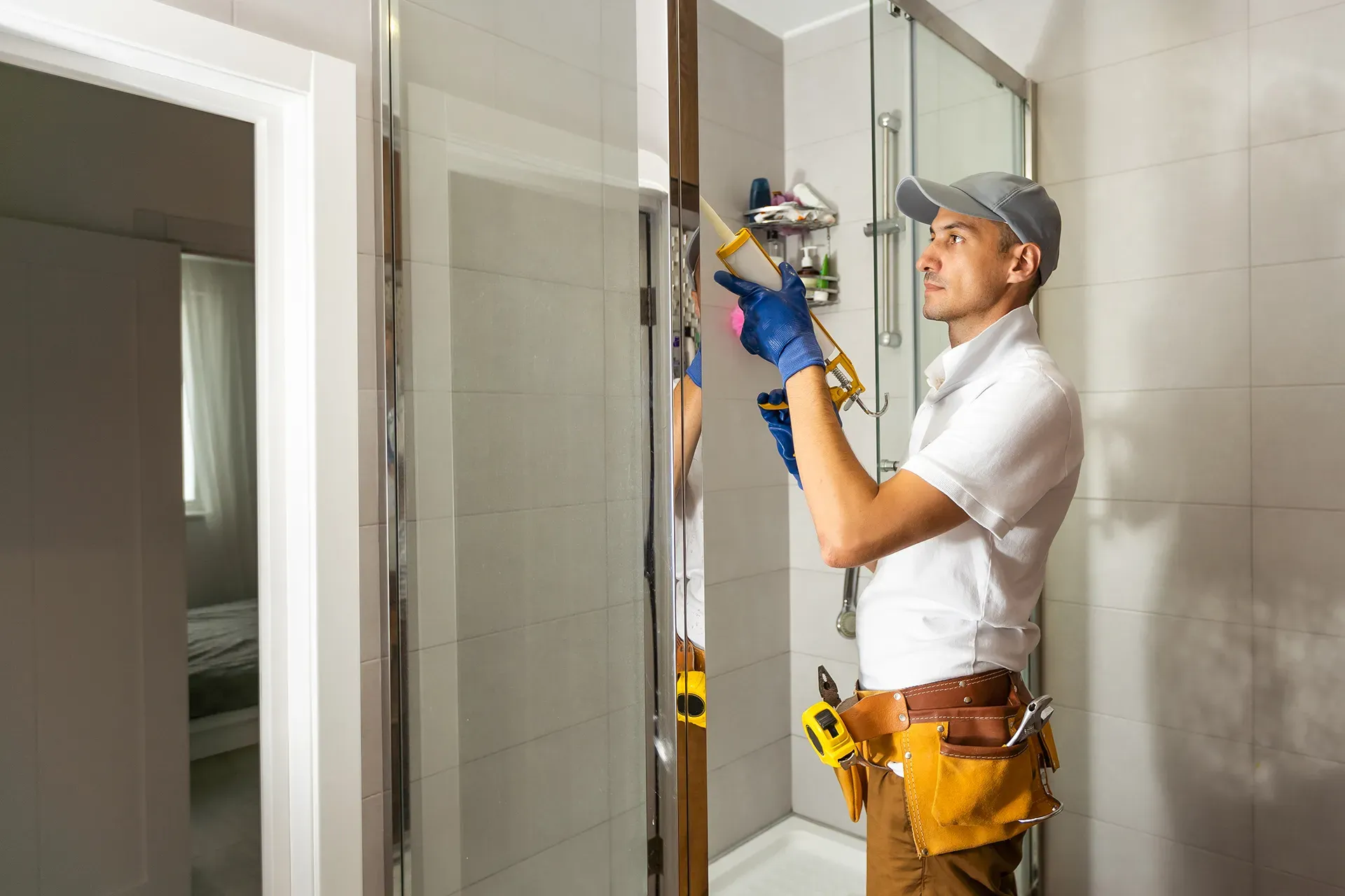 A person installing a glass shower door 